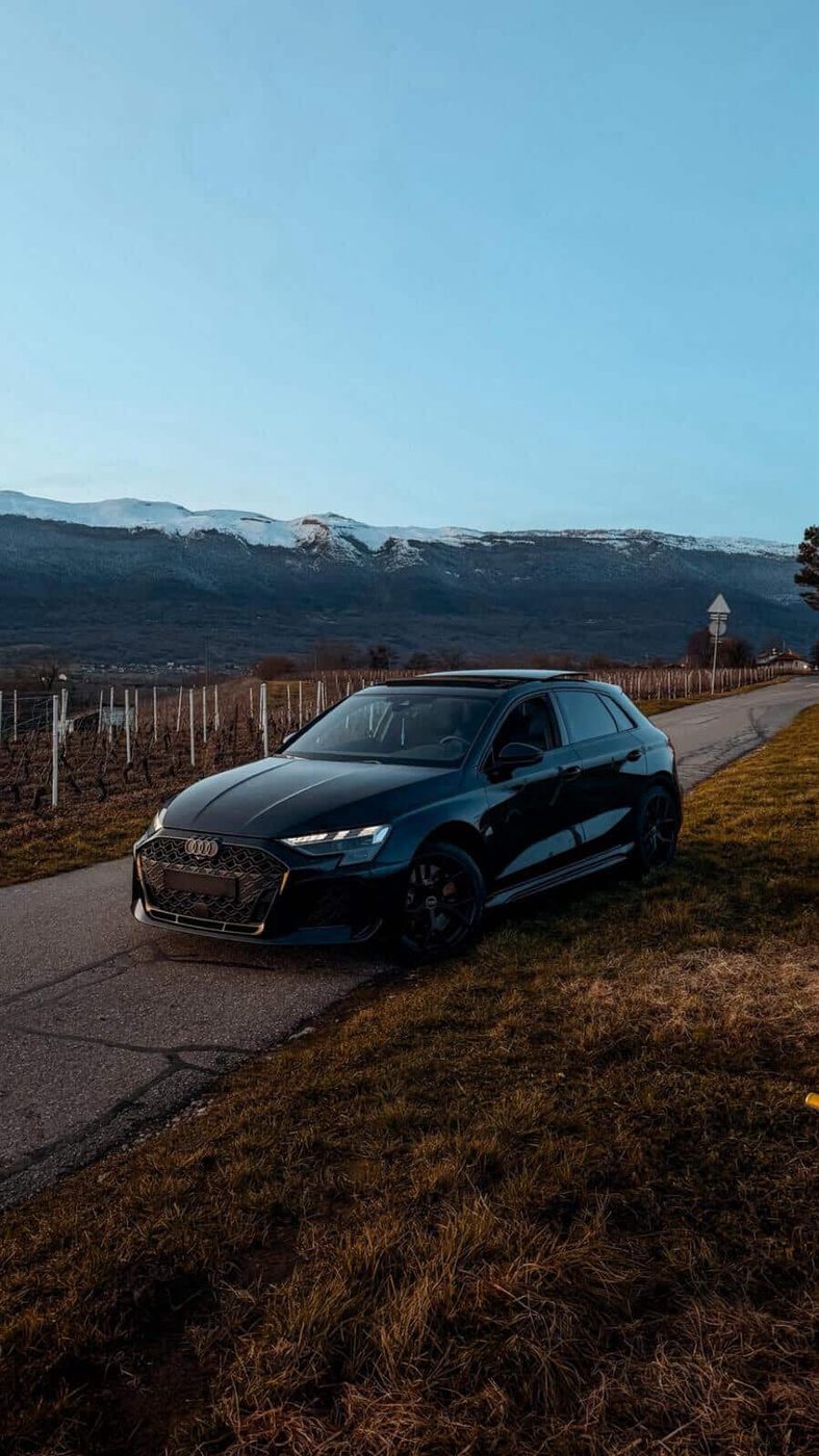 Audi RS3 Sportback 2025 noire devant les vignes et les montagnes du Léman